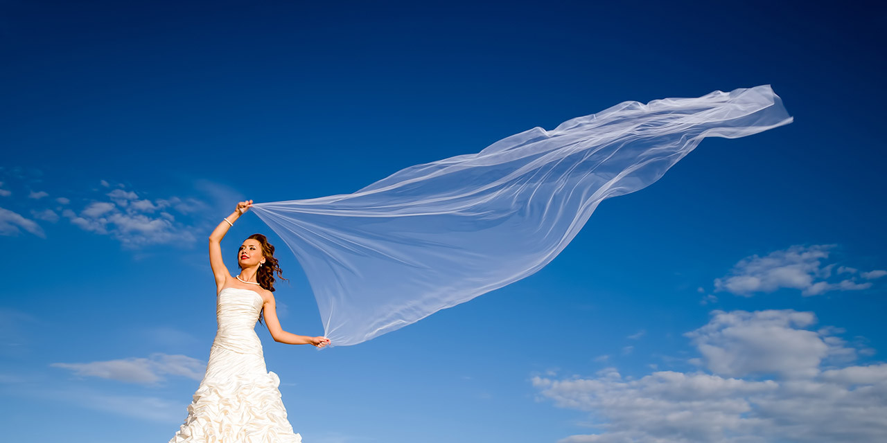 bride with windblown scarf on a tropical beach