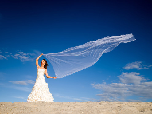 bride with windblown scarf on a tropical beach