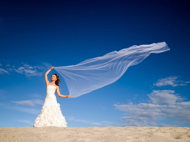 bride with windblown scarf on a tropical beach